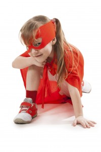 Superhero little girl in a red raincoat and a mask